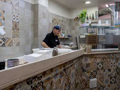 Facciamo un salto all�intermo, l� dove il lungo banco da impasto decorato con piastrelle colorate nasconde parzialmente Alessandro...
